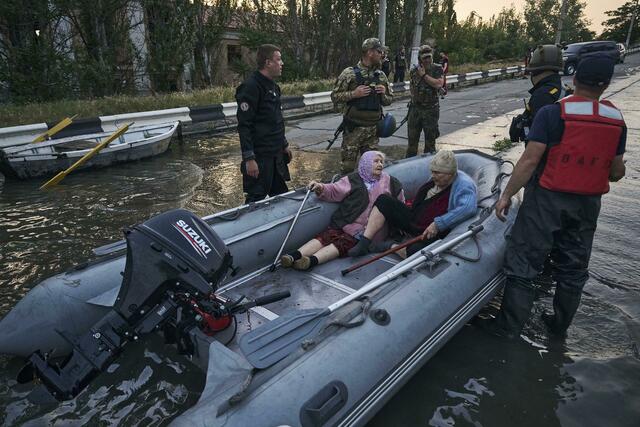 Viertel von Cherson stehen unter Wasser. Rettungskräfte evakuieren Bewohnerinnen mit Booten. | Foto:  Libkos/AP/dpa