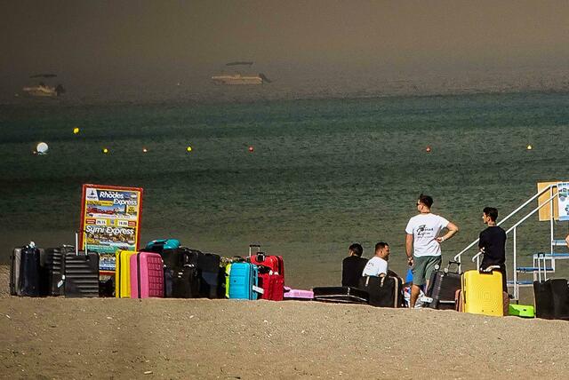 Menschen warten auf der griechischen Insel Rhodos darauf, vor den katastrophalen Waldbränden in Sicherheit gebracht zu werden. Foto: Argiris Mantikos/XinHua/dpa