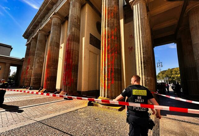 Sogenannte Aktivisten haben das Brandenburger Tor mit oranger Farbe angesprüht.  | Foto: Paul Zinken/dpa