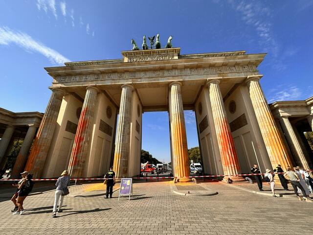 Mitglieder der Klimaschutzgruppe Letzte Generation haben das Brandenburger Tor mit oranger Farbe angesprüht.  | Foto: Paul Zinken/dpa