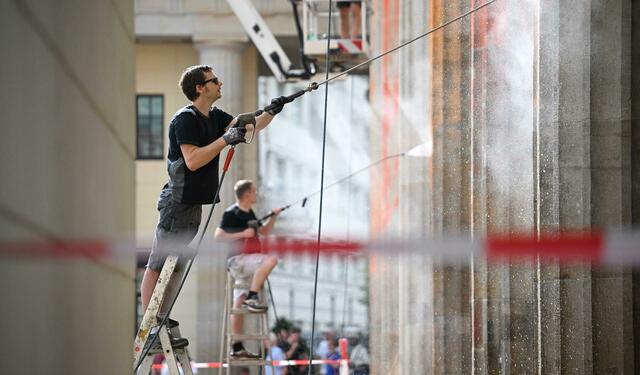 Reinigungsarbeiten nach einem Farbanschlag der so genannten letzten Generation auf das Brandenburger Tor.   | Foto: Britta Pedersen/dpa