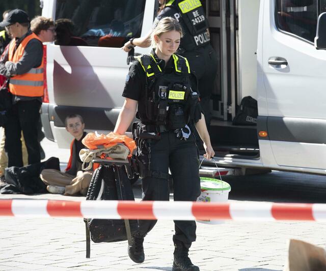 Mitglieder der Gruppierung Letzte Generation hatten am Sonntagvormittag das Brandenburger Tor mit oranger Farbe angesprüht. Die Polizei nahm nach eigenen Angaben 13 Mitglieder vor Ort fest.  | Foto: Paul Zinken/dpa