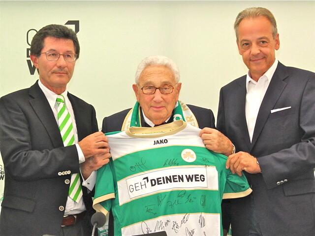 Im Jahr 2012 übergaben der damalige SpVgg-Präsident Helmut Hack (l.) und der seinerzeitige Vorstandsvorsitzende der Ergo Direct, Peter M. Endres, Dr. Henry Kissinger ein von der Mannschaft unterschriebenes Spielertrikot. | Foto: Udo Dreier