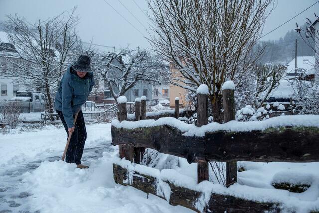 Ein Mann schaufelt in Kordel, Rheinland-Pfalz, Schnee von der Straße.  | Foto: Harald Tittel/dpa