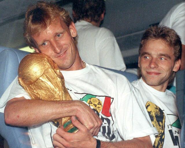 Andreas Brehme (l) mit dem WM-Pokal nach dem Finalsieg 1990 gegen Argentinien. Rechts daneben sein Mitspieler Thomas Häßler.  | Foto: Frank Kleefeldt/dpa