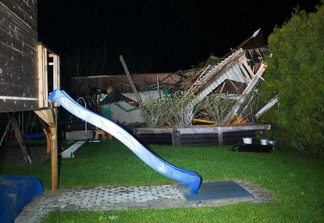 Ein beschädigtes Dach ist hinter einer Wiese zu sehen.  | Foto: Vifogra / Eberlein/vifogra/dpa