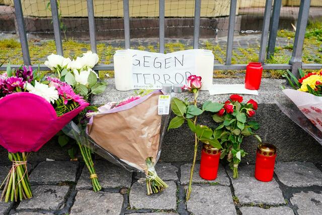 Kerzen, Blumen und ein Blatt Papier mit der Aufschrift «Gegen Terror» stehen am Tatort auf dem Mannheimer Marktplatz. | Foto: Uwe Anspach/dpa