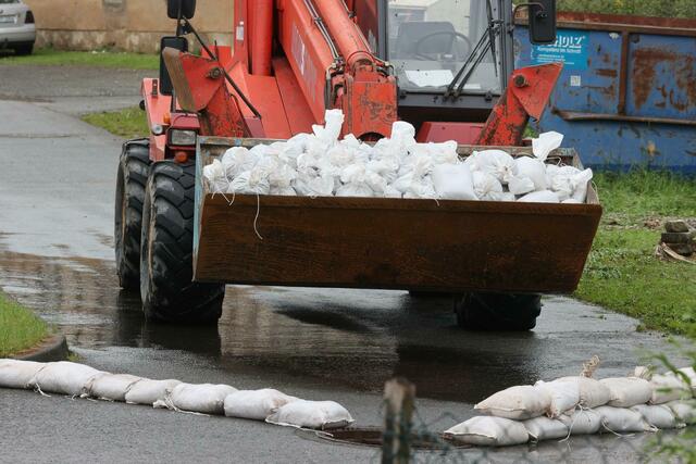 Ein Radlader transportiert in Hilbersdorf in Ostthüringen Sandsäcke.  | Foto: Bodo Schackow/dpa