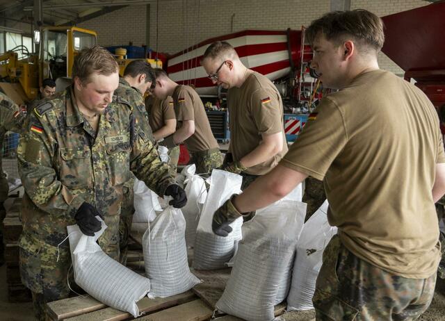 In einem Betonwerk füllen Soldaten der Bundeswehr Sandsäcke ab.  | Foto: Stefan Puchner/dpa