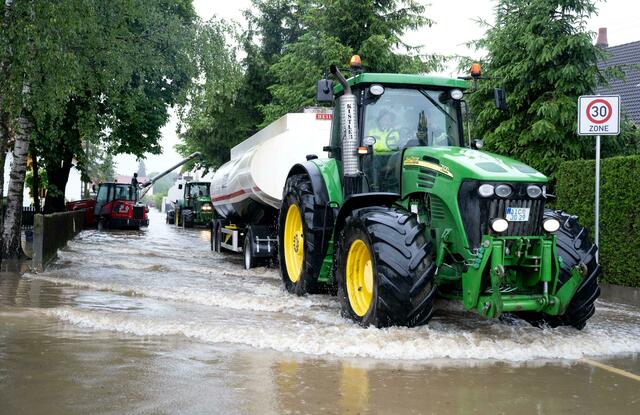Feuerwehrleute und Helfer pumpen das Wasser von den Straßen in Tankwagen in Dasing in Aichach-Friedberg. Bundeswehrsoldaten sind im Kampf gegen das Hochwasser in Bayern im Einsatz. "Die Bundeswehr unterstützt die beiden Landkreise Günzburg und Aichach-Friedberg, nachdem beide Landkreise einen offiziellen Antrag gestellt hatten", sagte eine Bundeswehr-Sprecherin des Landeskommandos Bayern.  | Foto: Sven Hoppe/dpa