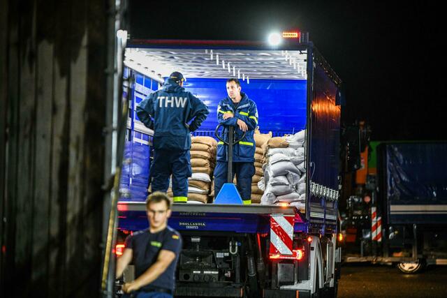 Einsatzkräfte des Technischen Hilfswerks (THW) laden am Logistikzentrum Sandsäcke für Süddeutschland.  | Foto: Jason Tschepljakow/dpa