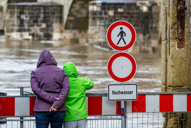 Ein Schild warnt an der Steinernen Brücke vor dem Hochwasser der Donau. Wegen extremer Regenfälle und drohenden Donauhochwassers hat der Landkreis Neuburg-Schrobenhausen als achte Kommune in Bayern den Katastrophenfall ausgerufen. Grund ist das Anschwellen der Donau und ihrer Zuflüsse, wie das Landratsamt der oberbayrischen Kommune am Samstagabend mitteilte.  | Foto:  Armin Weigel/dpa