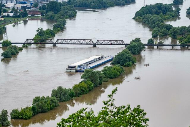 Zwei Schiffe liegen im Hochwasser der Donau. In Bayern herrscht nach heftigen Regenfällen vielerorts weiter Land unter.  | Foto: Armin Weigel/dpa