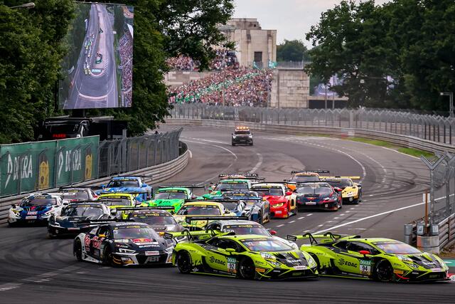 Und ab geht die Post: Das Feld biegt geschlossen in die Grundigkehre ein. Im Hintergrund die bestens gefüllte Steintribüne. | Foto: ADAC Motorsport