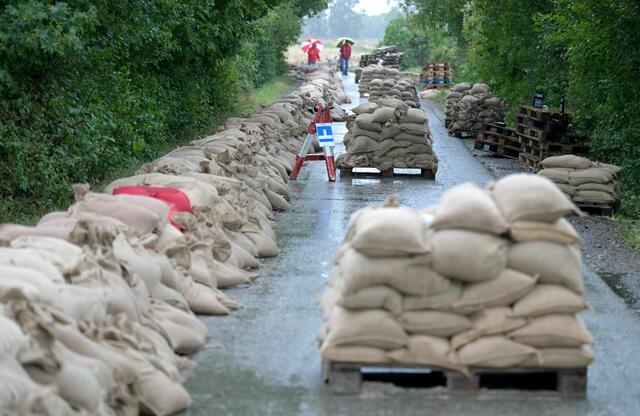 Mit Sandsäcken gegen die Fluten: Die Österreicher bauen Dämme auf.

 | Foto: Roland Schlager/APA/dpa