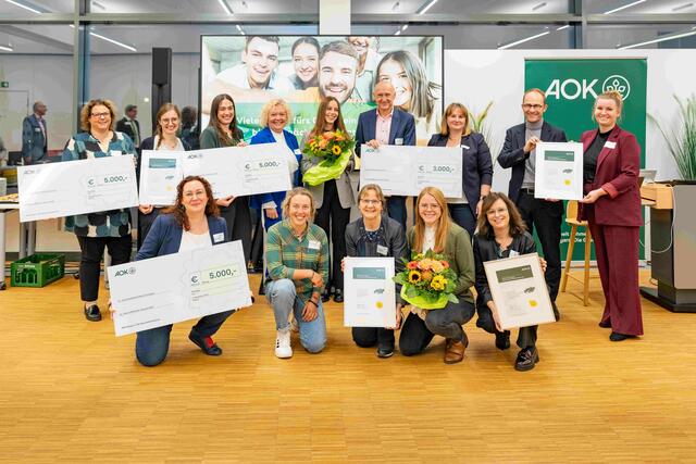 Reihe vorne (v.l.n.r.): Verena Neubauer (Universitätsklinikum Erlangen), Laura Dahlmeier, Elke Schmidt und Bianca Adler (Universitätsklinikum Erlangen), Ulrike Nöth (Gesundheitsnetz QuE)
Reihe hinten (v.l.n.r.): Katharina Ehinger und Jasmin Hildner (Diakonisches Werk Coburg), Alina Wimmer und Cornelia Uschold (Constantia Pirk), Julia Oelmayer (Gesundheitsnetz QuE), Horst Leitner (Direktor AOK Nürnberg), Annette Lutz (Bereichsleitung Gesundheitsförderung AOK Bayern), Stephan Abele (Vorstandsvorsitzender der AOK Bayern), Christina Heinemann (Universitätsklinikum Erlangen)
 | Foto: AOK