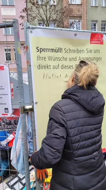 Eine Bürgerin schreibt auf ein Feedback-Plakat ihre Meinung zum wilden Müll. | Foto: Nicola A. Mögel / Stadt Nürnberg