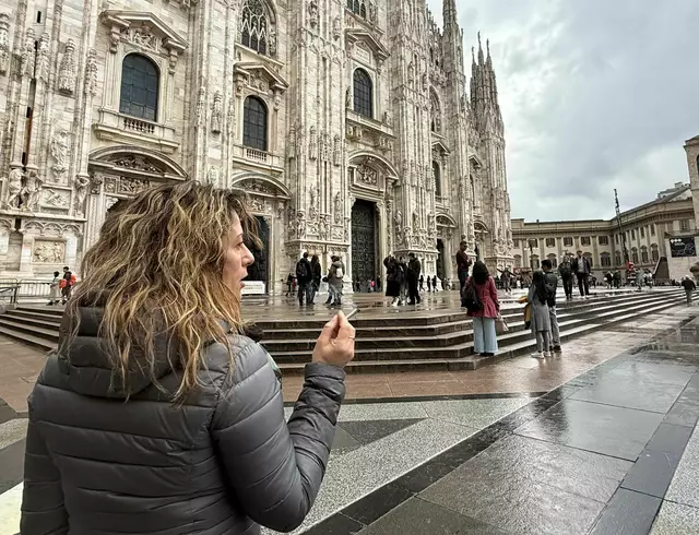 Eine Touristin mit Zigarette in der Hand vor dem Dom in Mailand. | Foto: Christoph Sator/dpa