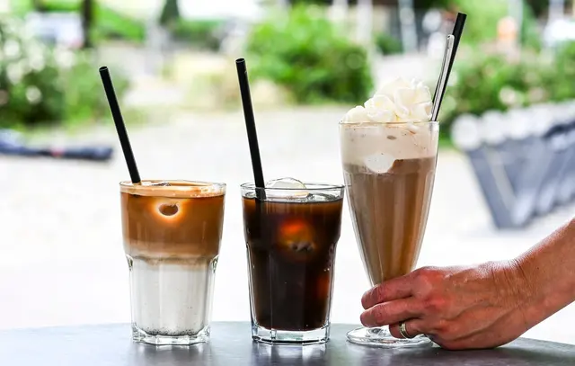 Iced Latte, Iced Coffee (also Kaffee mit Eiswürfeln) und klassischer Eiskaffee mit Vanilleeis und Sahne - präsentiert in einem Berliner Café. | Foto: Jens Kalaene/dpa (Symbolbild)