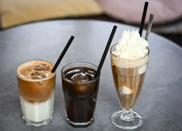 Iced Latte (also geeister Milchkaffee) und Iced Coffee sind puristischer als der sahnige Wiener Eiskaffee, der früher der Inbegriff von Eiskaffee in Deutschland war.
 | Foto: Jens Kalaene/dpa (Symbolbild)