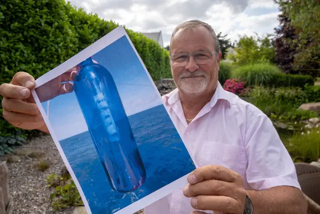 Jörg Wanke zeigt ein Foto seiner Flaschenpost. | Foto: Stefan Sauer/dpa