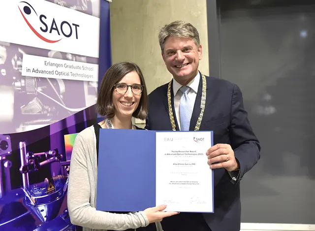 Prof. Joachim Hornegger (FAU-Präsident) überreicht den SAOT Young Researcher Award 2025 an Dr. Alba Alfonso García. | Foto: © FAU/Boris Mijat
