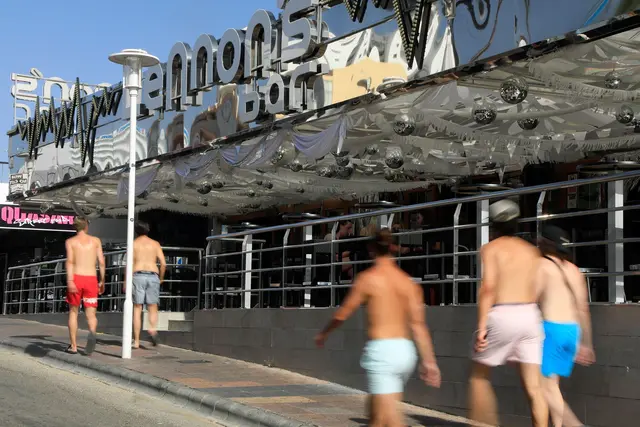 Junge Männer gehen mit nacktem Oberkörper auf Mallorca spazieren.  | Foto: Clara Margais/dpa (Archivbild)