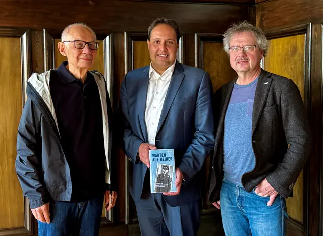 Autor Hans Pühn (links) und Museumsleiter sowie Stadtarchivar Guido Schmid (rechts) übergaben dem Bürgermeister Andreas Buckreus ein druckfrisches Exemplar von „Warten auf Heiner“ im Rother Rathaus.  | Foto: Stadt Roth
