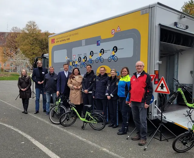 Übergabe von Lkws zur Verkehrserziehung am Dienstag, 28. Oktober 2025, auf dem Pausenhof der Konrad-Groß-Schule: mit Projektbeteiligten sowie Oberbürgermeister Marcus König (4. von links) und Schulreferentin Cornelia Trinkl (5. von links) und Polizeivizepräsident Gernot Rochholz (6. von links).
 | Foto: Eva Hesse / Stadt Nürnberg