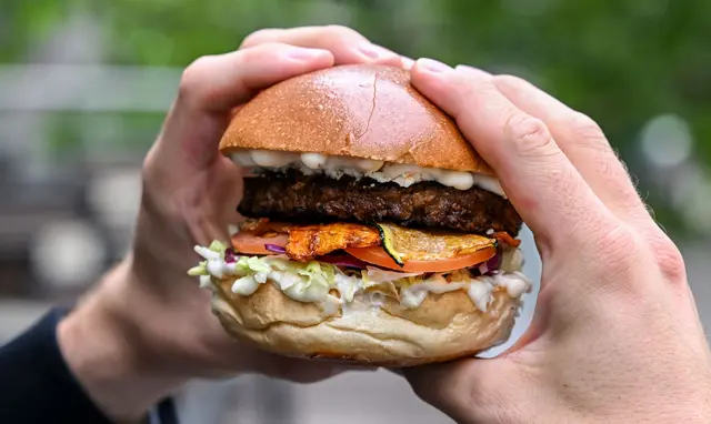 Ist nicht das, wonach es aussieht: Dieser Burger ist mit einem vegetarischen Patty belegt.  | Foto: Jens Kalaene/dpa (Archivbild)