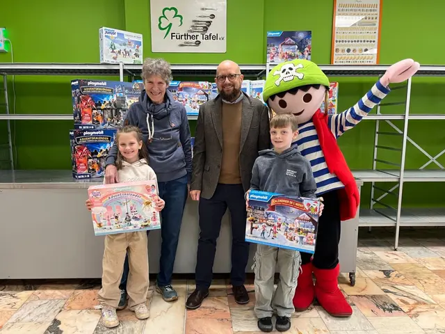 Spendenübergabe bei der Fürther Tafel: Die stellvertretende Vorsitzende Jutta Hammer, die Kinder Lea und Bastian, Tim-Niklas Kubach, Pressesprecher der Horst Brandstätter Group, und das PLAYMOBIL-FunPark-Maskottchen Rico freuen sich über die Aktion mit 130 Adventskalendern für Kinder aus armutsbetroffenen Familien. | Foto: Horst Brandstätter Group