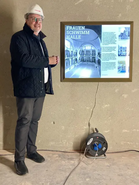 Bürgermeister Christian Vogel vor der ersten exemplarischen Geschichtstafel für die ehemalige Frauenschwimmhalle im Volksbad. | Foto: Christian Pröbiuß / Stadt Nürnberg