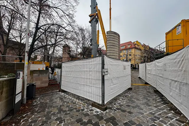 Fußgänger und Fußgängerinnen gelangen durch einen Bauzaun-Korridor sicher durch die Baustelle zum Kettensteg. | Foto: André Winkel / Stadt Nürnberg