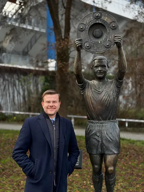 Oberbürgermeister Marcus König steht neben der Statue der Nürnberger Fußball-Legende Max Morlock am Max-Morlock-Stadion. | Foto: Sven Heublein