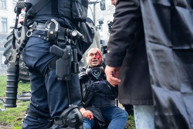 Ein Demonstrant sitzt verletzt auf einem Bordstein. | Foto: Marius Burgelman/AP/dpa