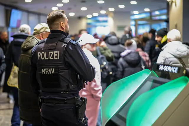 Aufgebrachte Kunden diskutieren vor der Sparkassenfiliale in Buer mit Polizeibeamten nach der Räumung des Vorraums der Filiale. | Foto: Christoph Reichwein/dpa