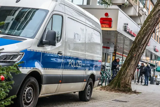 Aufgebrachte Kunden diskutieren vor der Sparkassenfiliale in Buer mit Polizeibeamten nach der Räumung des Vorraums der Filiale. | Foto: Christoph Reichwein/dpa