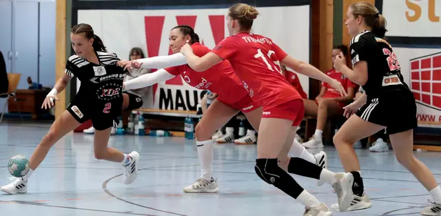 Das Foto zeigt links Mia Fuchs (schwarzes HCE-Trikot mit der Nr. 2) bei der Vorbereitung eines Angriff des HC Erlangen gegen die Abwehr des TV Nieder-Olm (rotes Trikot). Foto: #JockiFoto #Erlangen