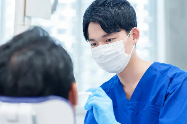 Zahnarzt führt eine klinische Untersuchung bei einem Patienten durch. | Foto: stock.adobe.com | taka