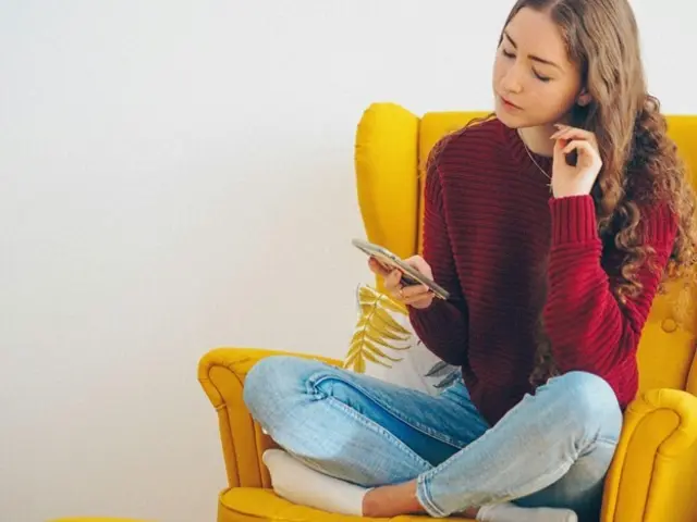 Foto: https://unsplash.com/de/fotos/frau-in-rotem-pullover-und-blauer-jeans-sitzt-auf-gelbem-sofa-YMQXOXMLXbY 
