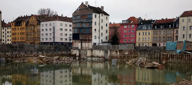Die trostlose Baugrube - Lago di Aufseß genannt - verschandelt seit Projektstopp die Südstadt. Der Stillstand auf dem Areal des ehemaligen Schocken-Kaufhauses (zuletzt Horten/Kaufhof) am Nürnberger Aufseßplatz herrscht im Wesentlichen seit Mitte 2021. Nach dem Abriss des Gebäudes, der Anfang 2021 begann und bis zum Sommer 2021 abgeschlossen war, entstand eine große Baugrube, die über Jahre ungenutzt blieb.  | Foto: Jürgen Friedrich
