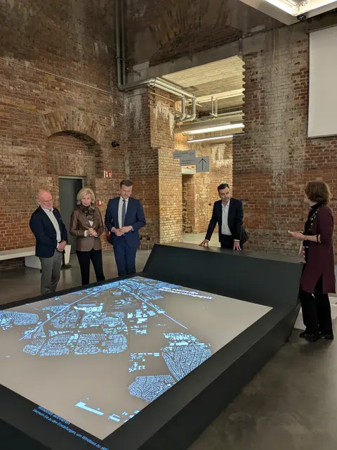  Dr. Thomas Eser, Direktor der Museen der Stadt Nürnberg, Bürgermeisterin Prof. Dr. Julia Lehner, Oberbürgermeister Marcus König und Dr. Imanuel Baumann, Leiter des Dokumentationszentrums Reichsparteitagsgelände, erhalten von Dr. Martina Christmeier, Kuratorin der neuen Dauerausstellung, Erläuterungen zum Geländemodell. | Foto: Dokumentationszentrum Reichsparteitagsgelände, Theresia Heinz