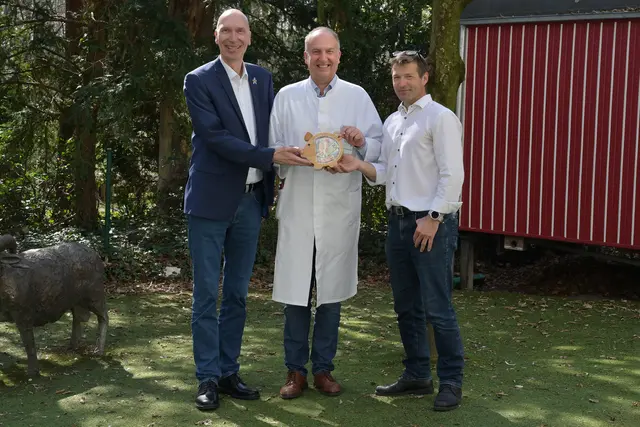 Holger Schmidt (l.) und Steffen Polster (r., beide Siemens Healthineers) überreichten Prof. Dr. Joachim Wölfle das randvolle „Spendenschweinchen“. | Foto: Franziska Männel/Uniklinikum Erlangen