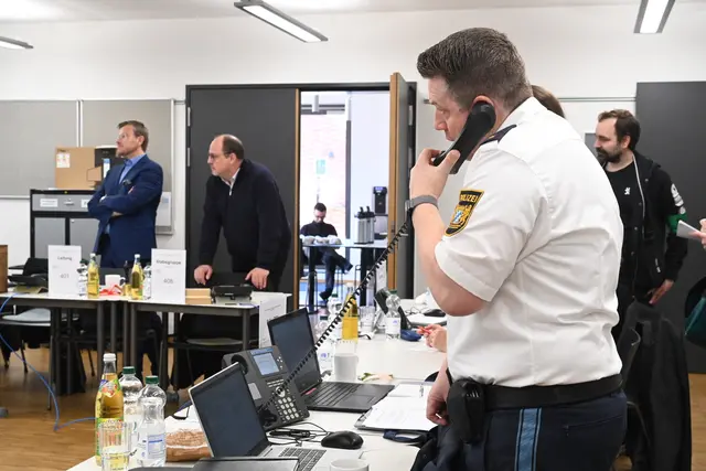In der Führungsgruppe Katastrophenschutz (FüGK), der auch Oberbürgermeister Marcus König (links) und Bürgermeister Christian Vogel (Mitte) angehören, koordiniert ein Polizeibeamter telefonisch Abläufe. | Foto: Christine Dierenbach / Stadt Nürnberg