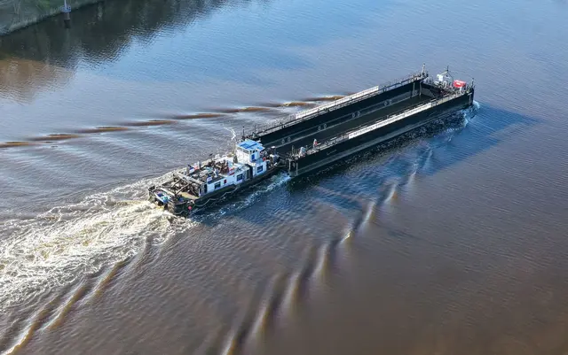 Ein Lastkahn, geschoben von dem Schubschiff «Hans» fährt auf dem Nord-Ostsee-Kanal. | Foto: Bodo Marks/dpa