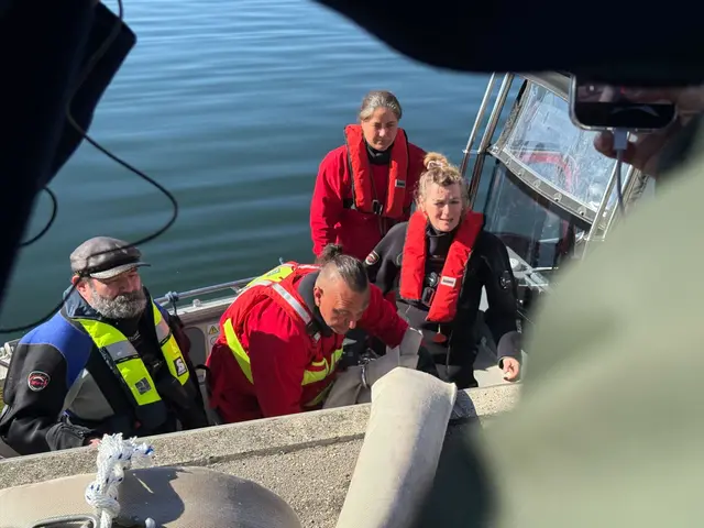 Helfer besteigen ein Boot, um zum Wal hinauszufahren. | Foto: Helena Dolderer/dpa