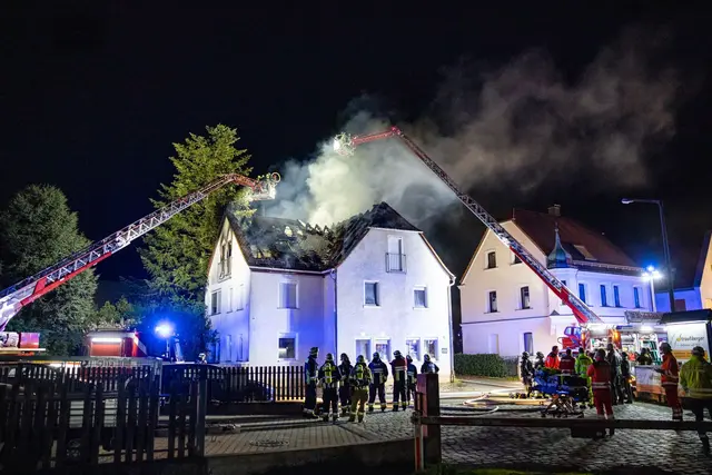 Einsatzkräfte der Feuerwehr sind mit einer Drehleiter am Brand eines Dachstuhls in Nürnberg beschäftigt. | Foto: David Oßwald/NEWS5/dpa