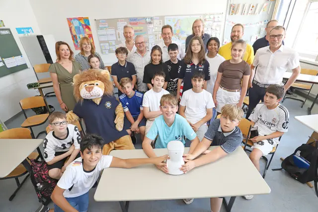 „Einfach cool“. So lautet das Urteil der sechsten Klasse in der Pestalozzischule, wo der Avatar ebenfalls schon im Einsatz war. Vertreterinnen und Vertreter des Lions Club Fürth, die Schulleitung sowie Bürgermeister Markus Braun freuen sich über die Begeisterung der Kinder.  | Foto: Ebersberger / Stadt Fürth