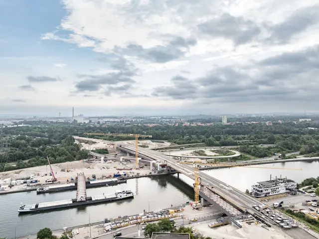 Lückenschluss über dem Main-Donau-Kanal: Am Dienstag, 30. Juni 2026, hat das Projekt Hafenbrücken eine weitere Hürde genommen. Zwei miteinander verzurrte Lastschiffe haben das 520 Tonnen schwere Brückenteil aus Stahl vom Ufer zur neuen Frankenschnellweg-Brücke transportiert.
 | Foto: Christian Höhn / Stadt Nürnberg