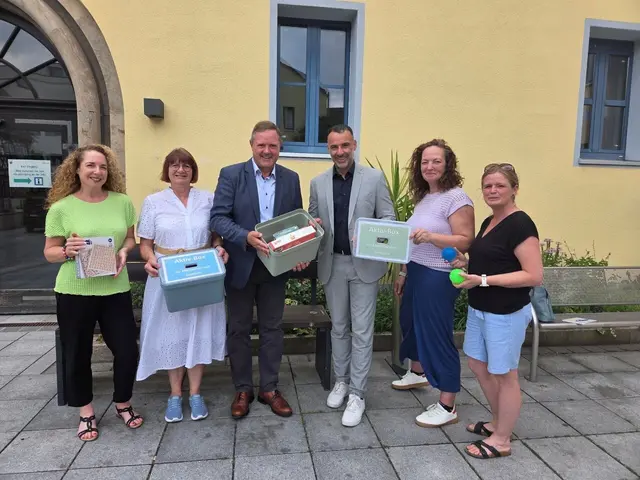 Tanja Maier, Koordinatorin für Seniorenangelegenheiten des Landkreises, Elke Zahl, Demenzbeauftragte der Stadt Zirndorf, Landrat Bernd Obst, Zirndorfs Bürgermeister Marcus Spath, Yvonne Götz, Koordinatorin im Pflegestützpunkt des Landkreises, und Kerstin Zechentmayer, Referentin für Soziales, Jugend und Senioren, präsentieren die beiden Demenzboxen vor dem Zirndorfer Rathaus (v. l.). | Foto: Stadt Zirndorf